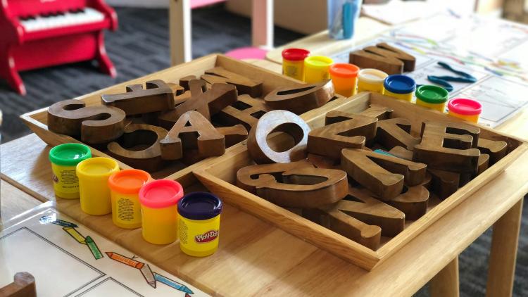 Kindergartenmotiv mit Buchstaben auf einem Tisch