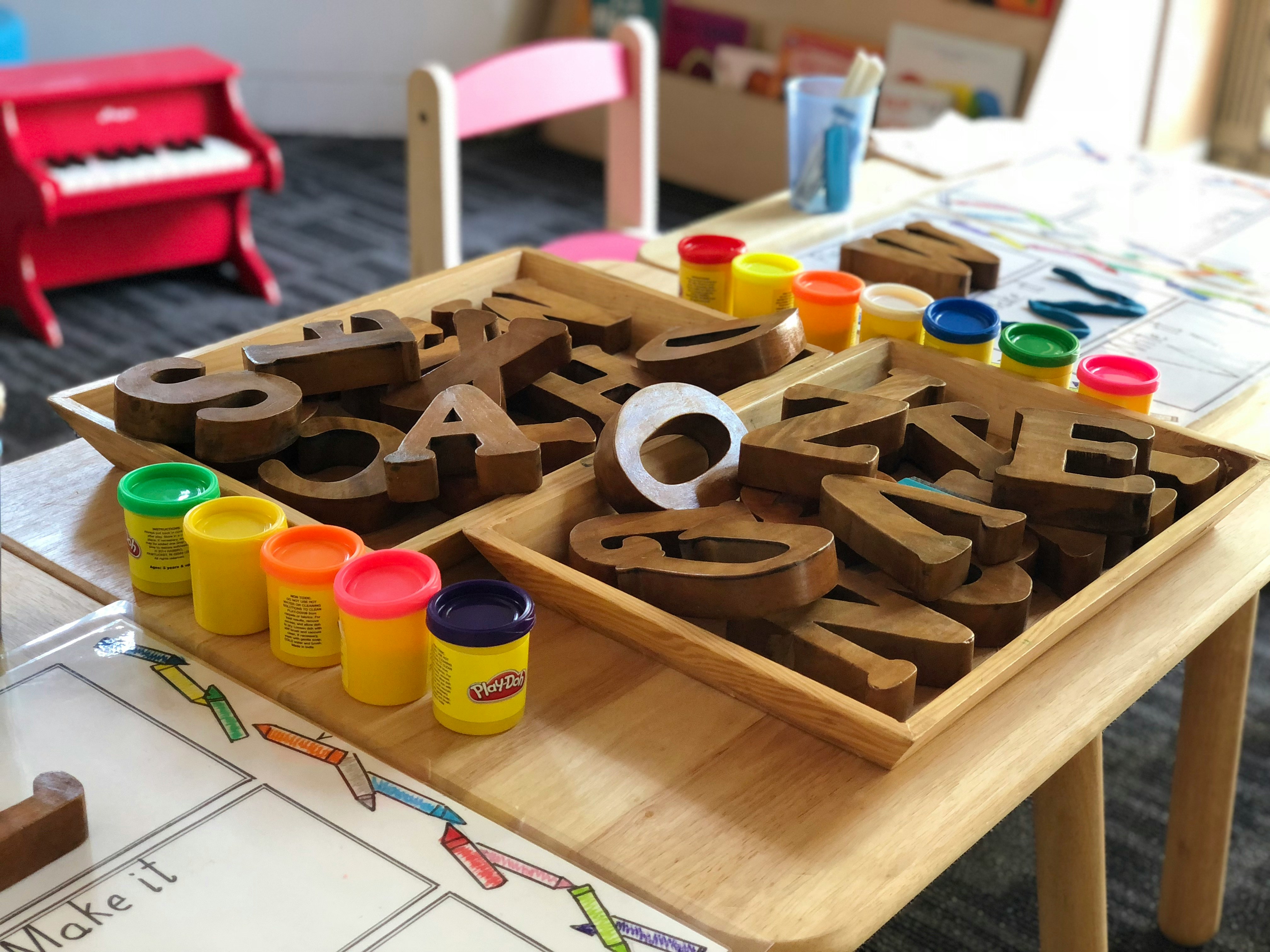 Kindergartenmotiv mit Buchstaben auf einem Tisch
