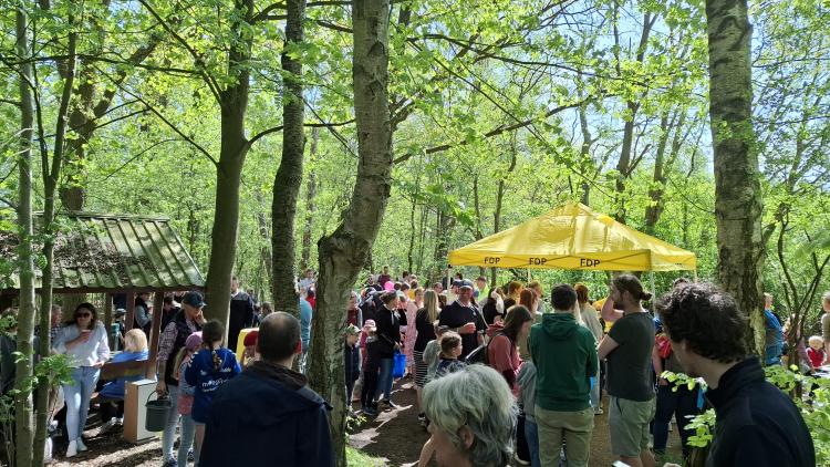Viele Menschen sammeln sich nahe eines FDP-Zeltes an der Alsterquelle in Henstedt-Ulzburg
